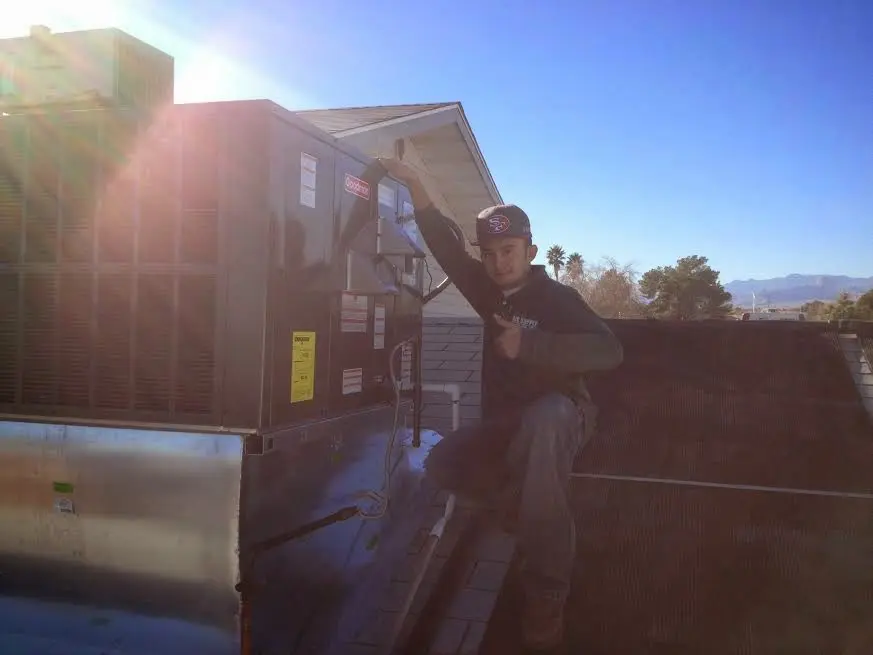 HVAC technician performing Heat Pump Repair on a rooftop unit in Granite Shoals