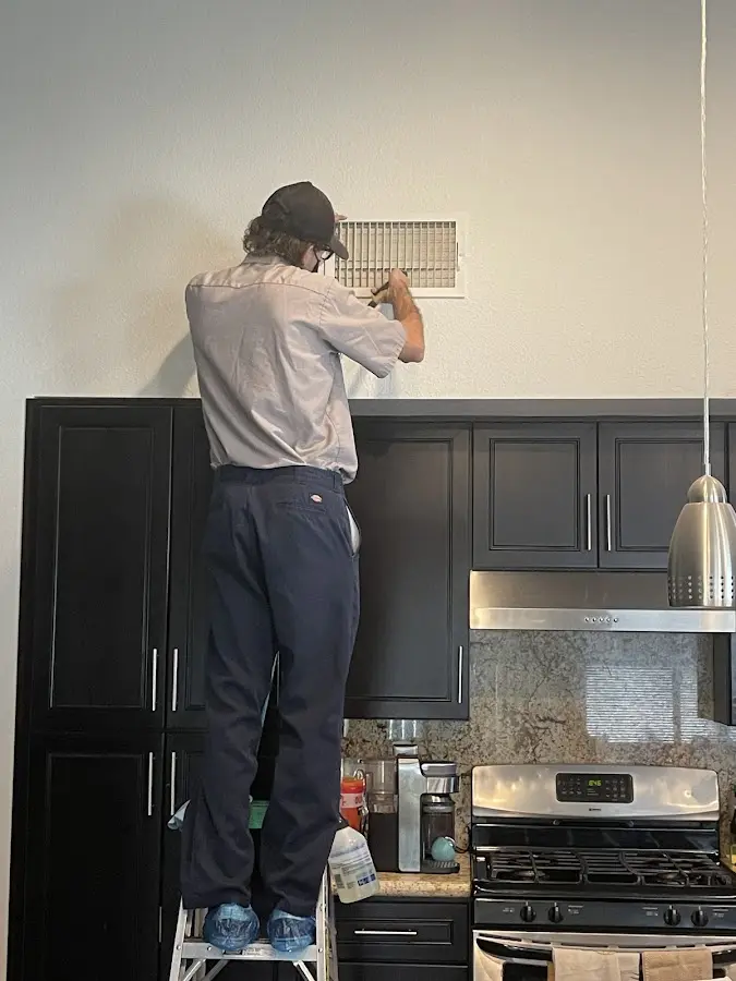 Technician inspecting an air vent during HVAC service in Granite Shoals